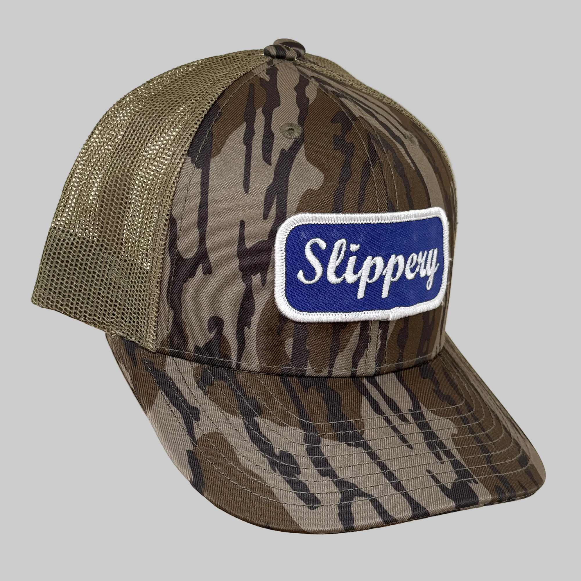 Camouflage trucker hat with 'Slippery' logo on a beige background